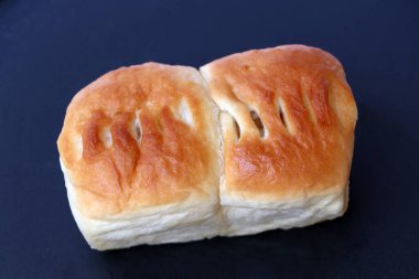 Kare şeklinde, ananas dolgulu ekmek, karanlık tabanda..