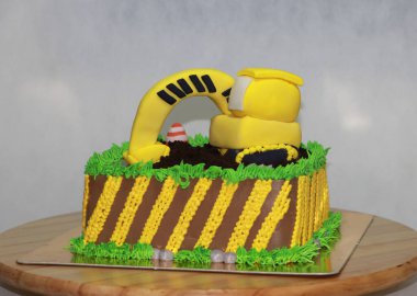 Yenilebilir Alloy Kazıcı Kamyon Araçları ve kare çikolatalı kekin üzerinde trafik konisi olan toprak yığını.