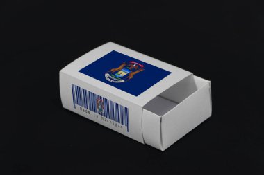 Barkodlu beyaz kutuda Michigan bayrağı ve siyah arka planda ulus bayrağı, eşleşme için kağıt ambalaj. Michigan 'dan ihracat ticareti kavramı. Amerika devleti..