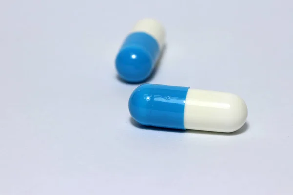 白い床に白と青の色の薬カプセルの山 それは小さなケースや容器 特に円形または円筒形のものです 医学的概念 — ストック写真