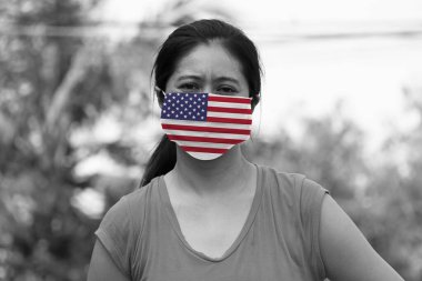 Amerika Birleşik Devletleri hijyenik maskeye bayrak dikti. Siyah ve beyaz maskeli kadın mikropları engelliyor. Virüs koronası konsepti veya 19 veya Minik Parçacık Koruması.