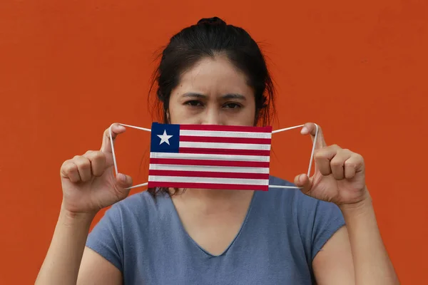 Woman Liberia Flag Hygienic Mask Her Hand Lifted Front Face — Stock Photo, Image