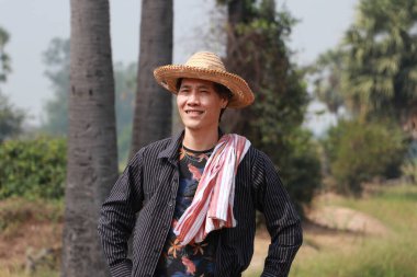 Tarımcı erkek, doğanın üzerinde duran bir şapka ve peştamal giyer..