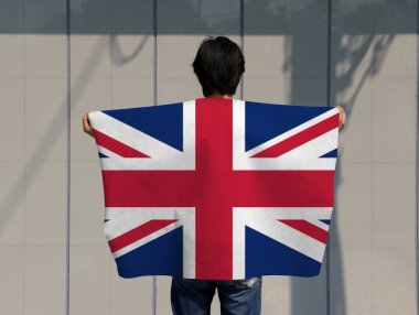 Adam omuzunda İngiliz bayrağı taşıyor ve gri arka plana dönüyor..