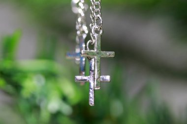 Ağacın dallarında asılı metal haç bileziği. inanç ve inanç kavramı.