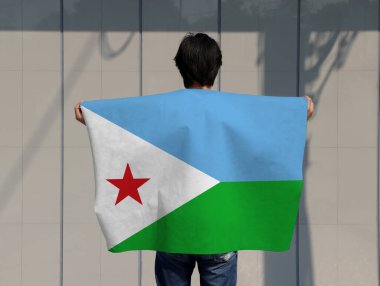 Adam Cibuti bayrağını omuzunda taşıyor ve gri arka planda geri dönüyor..