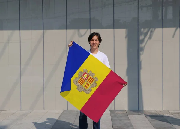 Homem Está Segurando Bandeira Andorra Suas Mãos Sobre Fundo Cinza — Fotografia de Stock