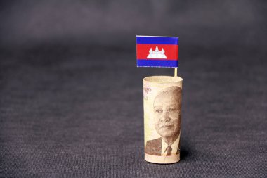 Beş bin Kamboçya Riel 'ı. Koyu gri zemin ve arka planda mini Kamboçya bayrağı. Finans sektörü kavramı.