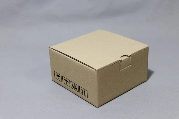 Brown carton box with fragile symbol beside it, paper packaging for put products. The concept of import or export trading.