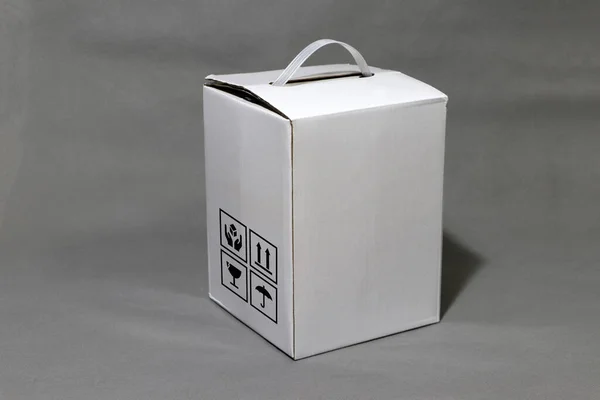 White carton box with fragile symbol beside it, paper packaging for put products. The concept of import or export trading.