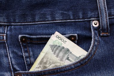 Banknote parası, kot pantolonun cebinde iki bin Kamboçyalı Riel. Tasarruf veya finans kavramı.