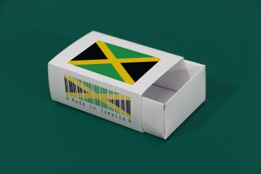 Beyaz kutuda barkodlu Jamaika bayrağı ve yeşil arka planda ulus bayrağı, kibrit veya ürünler için kağıt paketleme. Jamaika 'dan ihracat ticareti kavramı.