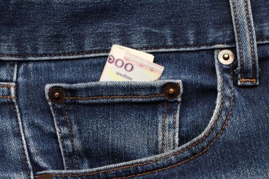 Banknote parası. Kot pantolonun küçük cebinde 100 Kamboçyalı Riel. Tasarruf veya finans kavramı.