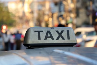 Caddenin çatısındaki kasvetli beyaz renkli ve siyah yazılı taksi tabelası ya da taksi tabelası bulanık arka plan, Myanmar.