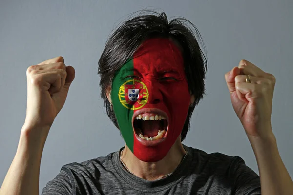 一个人脸上挂着葡萄牙国旗 灰色背景 他的画像很高兴 体育或民族主义的概念 — 图库照片