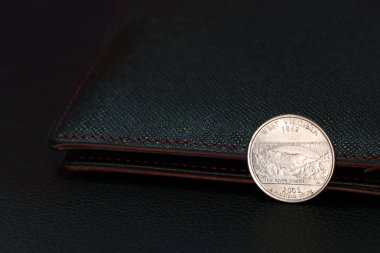 ABD Doları sikkelerinin dörtte biri geri viteste ve siyah cüzdanlı, finans kavramı.