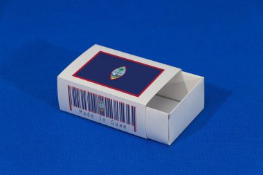 Barkodlu beyaz kutuda Guam bayrağı ve mavi arka planda ulus bayrağı, eşleştirme için kağıt ambalaj. Guam 'dan ihracat ticareti kavramı.