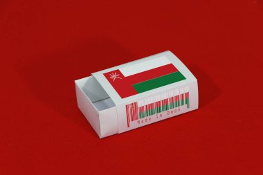Barkodlu beyaz kutuda Umman bayrağı ve kırmızı arka planda ulus bayrağı, eşleştirme için kağıt ambalaj. Umman 'dan ihracat ticareti kavramı..