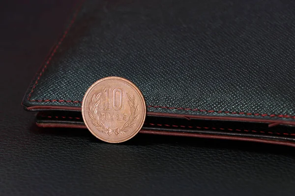 Geri viteste Japon 10 Yen (JPY) ve siyah cüzdan, finans kavramı.