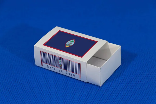 Barkodlu beyaz kutuda Guam bayrağı ve mavi arka planda ulus bayrağı, eşleştirme için kağıt ambalaj. Guam 'dan ihracat ticareti kavramı.