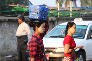 Yangon, Myanmar, 24 Şubat 2019: Yüzlerinde thanakha (Myanmar pudrası) olan Myanmalı kadın markete gitmekten kafasına plastik sepeti geçirdi.