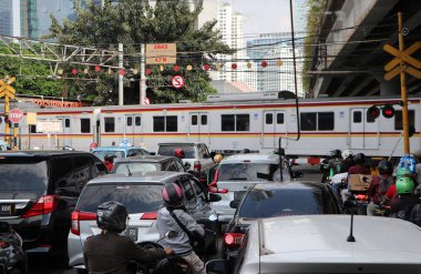 Jakarta, Endonezya 6 Mayıs 2019: Tren yolun karşısına geçiyor. Cakarta 'da trafiğin tıkanmasına neden olan arabanın beklemesine neden oldu..