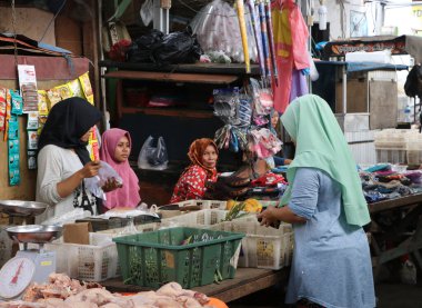 Jakarta, Endonezya 2 Mayıs 2019: Endonezyalı Müslüman ev hanımı, Jakarta 'daki yeni pazarda kadın sokak satıcılarından sebze satın alıyor.