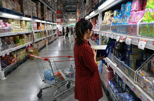 Muang, Pathum Thani, Tayland - 28 Ocak 2020: Makro süpermarketinin raflarında alışveriş yapan kadın müşteri.