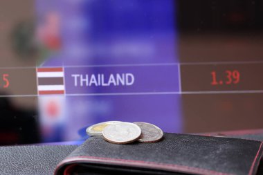 Siyah zemin üzerindeki siyah cüzdanda 20 baht Tayland sikkesi (bir on ve iki beş sikke) ve para değişimi para arkaplanı dijital panosu, finans kavramı.