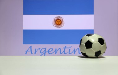 Beyaz zeminde küçük bir futbol topu ve Arjantin arkaplan arkaplanlı bir bayrak. Spor konsepti.