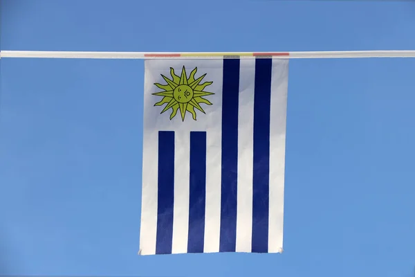 乌拉圭的迷你布线旗 有9条等水平条纹 蓝色与白色交替 象征太阳 它挂在蓝天背景的绳子上 — 图库照片