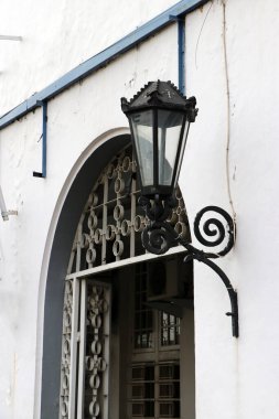 Kemerli kapının yanına siyah metal fener ve cam döşenmiş..