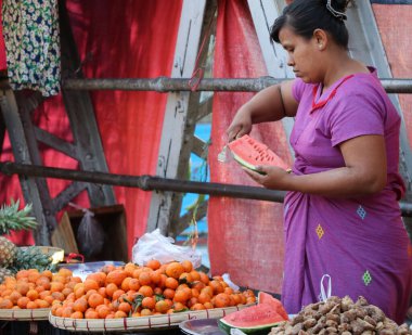 Yangon, Myanmar, 20 Şubat 2019: Meyve satan Myanmese 'li kadın sokak satıcısı Bogyoke Aung San Market' te veya Yangon 'daki Scott Market' te karpuz dilimliyor.