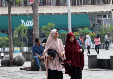 Jakarta, Endonezya 6 Mayıs 2019: Cakarta 'daki Fatahillah Meydanı' nda yürüyen iki Müslüman kadın.