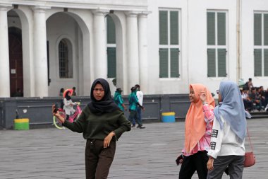 Jakarta, Endonezya 6 Mayıs 2019: Cakarta 'daki Fatahillah Meydanı' nda akıllı telefonla üç Müslüman kadın Selfie.