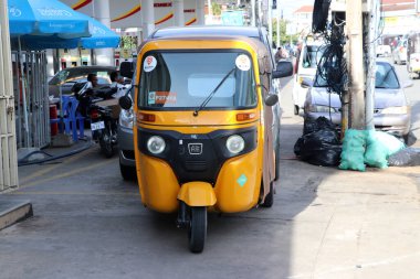 Phnom Penh, Kamboçya, 17 Ağustos 2019: Tuk Tuk ya da yolda sarı renkli üç tekerlekli taksi, Phnom Penh 'de trafiğin yaşam tarzı. Taksi olarak kullanılan üç tekerlekli motorlu bir araç..