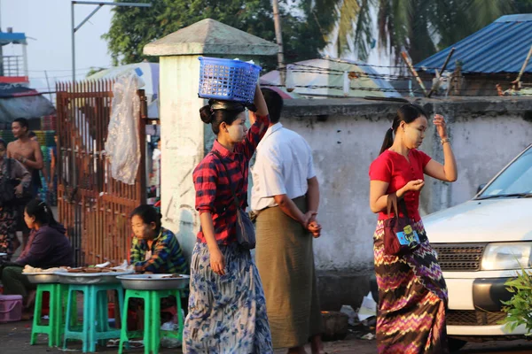 Yangon, Myanmar, 24 Şubat 2019: Yüzlerinde thanakha (Myanmar pudrası) olan Myanmalı kadın markete gitmekten kafasına plastik sepeti geçirdi.