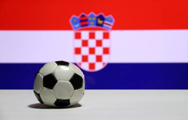 Beyaz zeminde, Hırvat ulusunun bayrak arka planının kırmızı beyaz ve mavi renklerine odaklanmış küçük bir futbol topu. Spor konsepti.