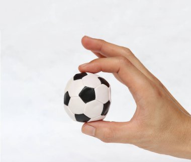 Mini futbol topu elinde, beyaz arka planda iki parmağınla tut. Spor kavramı ya da ele alınan oyun ya da küçük mesele.