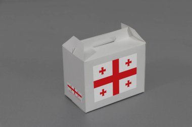 Barkodlu beyaz kutuda Georgia bayrağı ve gri arka planda ulus bayrağı. Gürcistan 'dan ihracat ticareti kavramı, ürünler için kağıt paketleme.