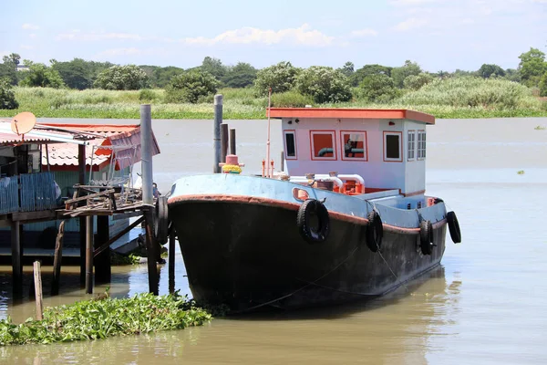 Tayland Chao Phraya Nehri 'ndeki küçük tekne iskelesine orta büyüklükte bir tekne iniyor..
