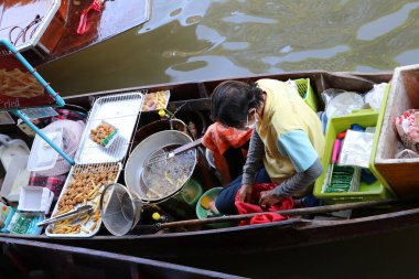 Damnoen Saduak, Ratchaburi, Tayland - 31 Aralık 2018: Damnoen Saduak yüzen marketindeki kanalda oturan kızarmış tavuk ve patates kızartması satıcısı.