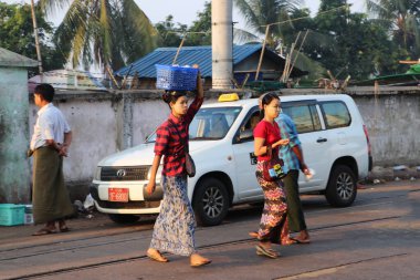 Yangon, Myanmar, 24 Şubat 2019: Yüzlerinde thanakha (Myanmar pudrası) olan Myanmalı kadın markete gitmekten kafasına plastik sepeti geçirdi.