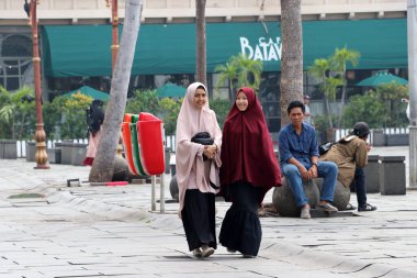 Jakarta, Endonezya 6 Mayıs 2019: Cakarta 'daki Fatahillah Meydanı' nda yürüyen iki Müslüman kadın.