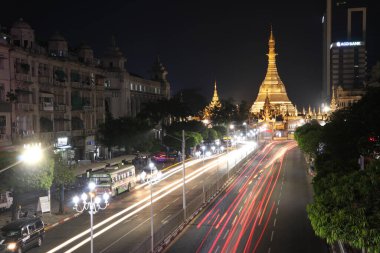 Yangon, Myanmar 21 Şubat 2019: Sula pagoda 'nın altın sekizgeninde gece vakti ve ışık hızı Yangon şehir merkezinde bina ve Sule Pagoda yolunun kesiştiği yerde birçok araba bulunuyor..