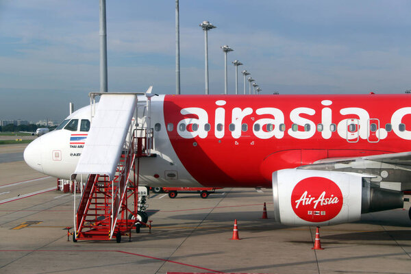 Don muang, Bangkok, Thailand, June 6, 2018 : Header section of the plane of Thai Airasia, Airbus A320  is parked on the parking lot and against the passenger boarding staircase to the door.