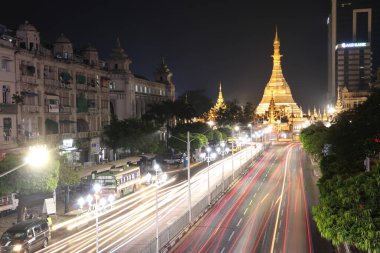 Yangon, Myanmar 21 Şubat 2019: Sula pagoda 'nın altın sekizgeninde gece vakti ve ışık hızı Yangon şehir merkezinde bina ve Sule Pagoda yolunun kesiştiği yerde birçok araba bulunuyor..