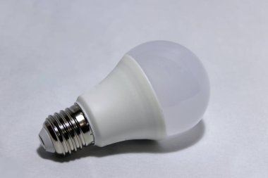 Beyaz arka planda beyaz ampul. Lambaya ya da tavandaki bir sokete yerleştirilmiş cam bir ampuldür. Elektrik akımının içinden ya da gaz cebinden geçen bir ışık sağlar..