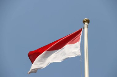 Endonezya 'nın ulusal bayrağı parlak mavi gökyüzü arka planında. Rüzgarla savruldu. Endonezya, Güneydoğu Asya Ulusları Birliği 'nin on üyesinden biridir..