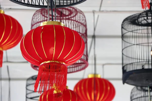 Red fabric lamps and bird cage lamps hanging on the ceiling. Welcome to the Chinese new year festival.